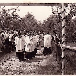 Takole se je Jure v sprevodu bližal svoji domači cerkvi in slavoloku “Novomašnik, bodi pozdravljen!” Fotografija iz arhiva družine Ivanušič – Mežnarovih.