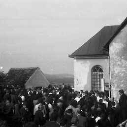 In spet se je ob preloški cerkvi trlo ljudi, le da oblečenih v žalno črnino; fotografija iz arhiva Janka Nartnika, fotograf Janez Kozjek.